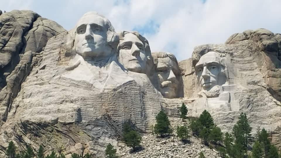 Mount Rushmore with four large stone faces carved into the mountain.
