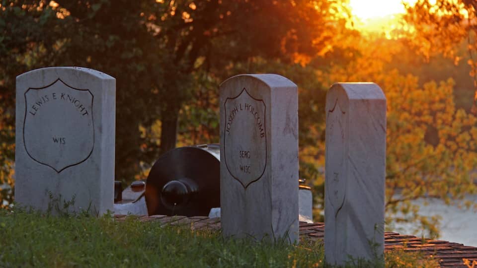 Three gravestones with names and locations engraved on them.