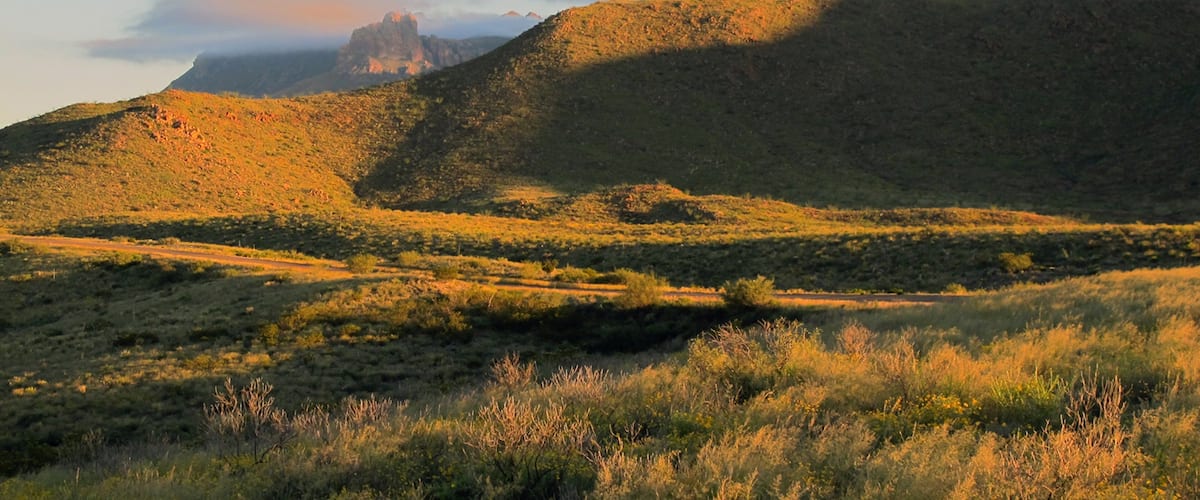 A mountainous landscape with a prominent peak and a valley.