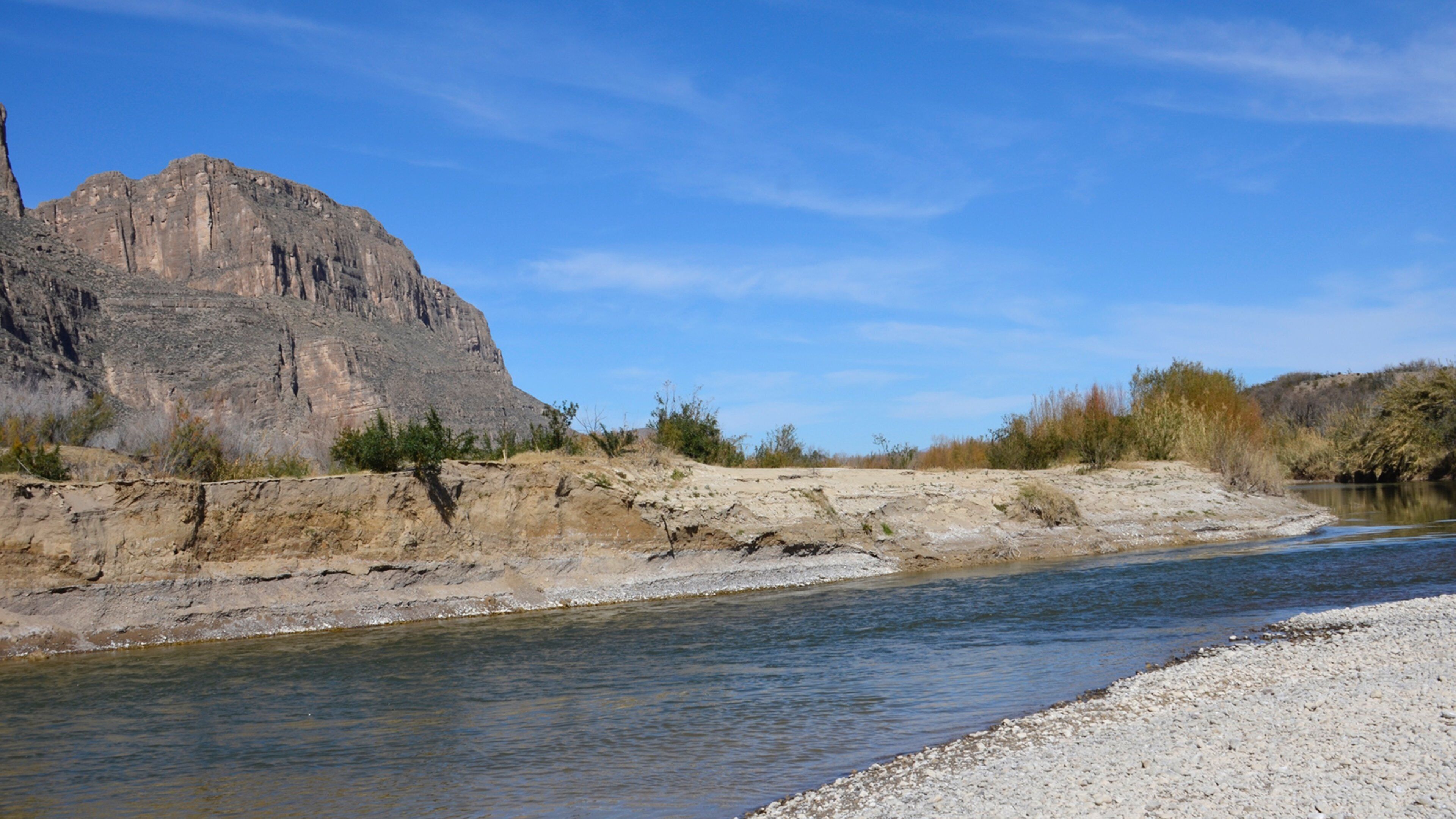 A river flowing through a rocky landscape with a prominent mountain in the background.