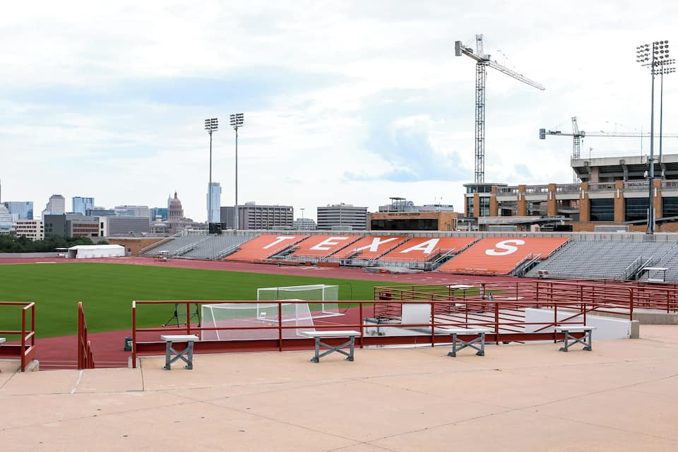 A stadium with "TEXAS" written on the seating and a green field.