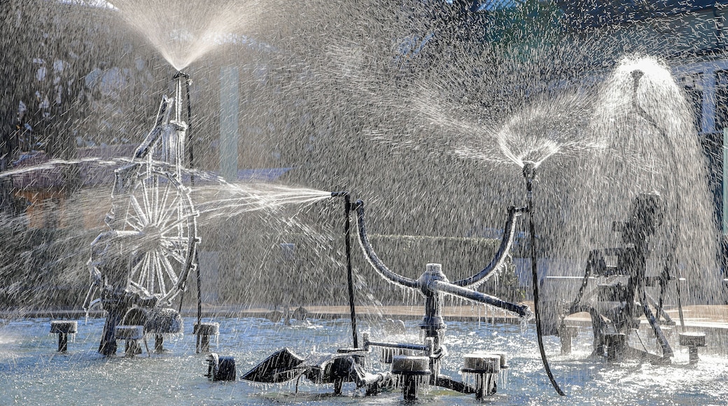The Tinguely fountain in the city center Basel with partly frozen parts and splashing in backlit in cold winter weather