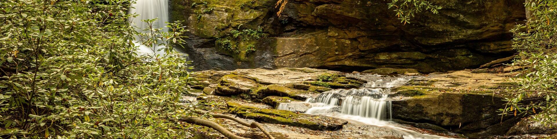 A waterfall cascading over rocks in a forested area.