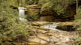 A waterfall cascading over rocks in a forested area.