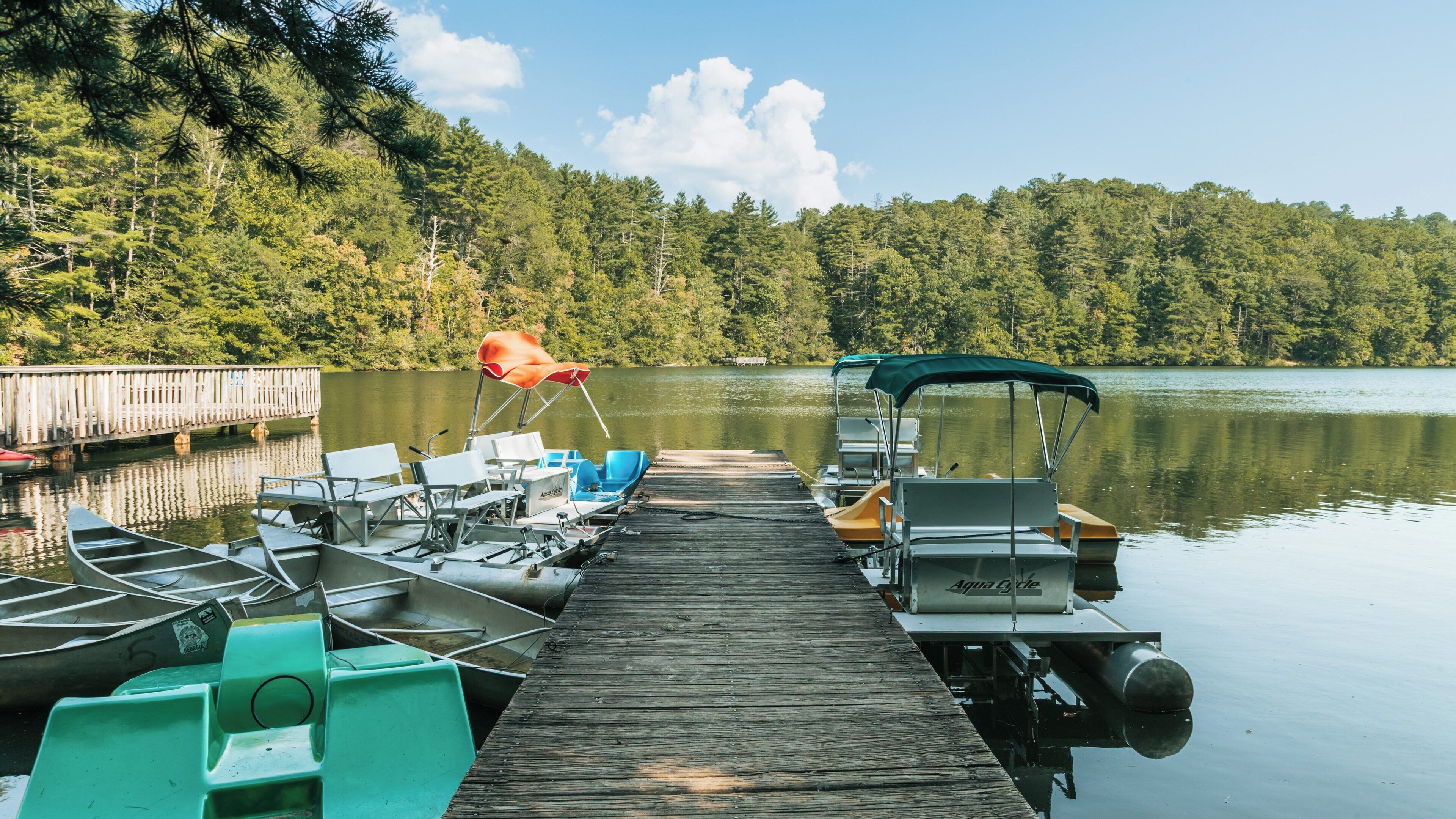 Unicoi State Park offers serene views of the lake with kayaks and boats docked along the wooden pier in Helen, Georgia