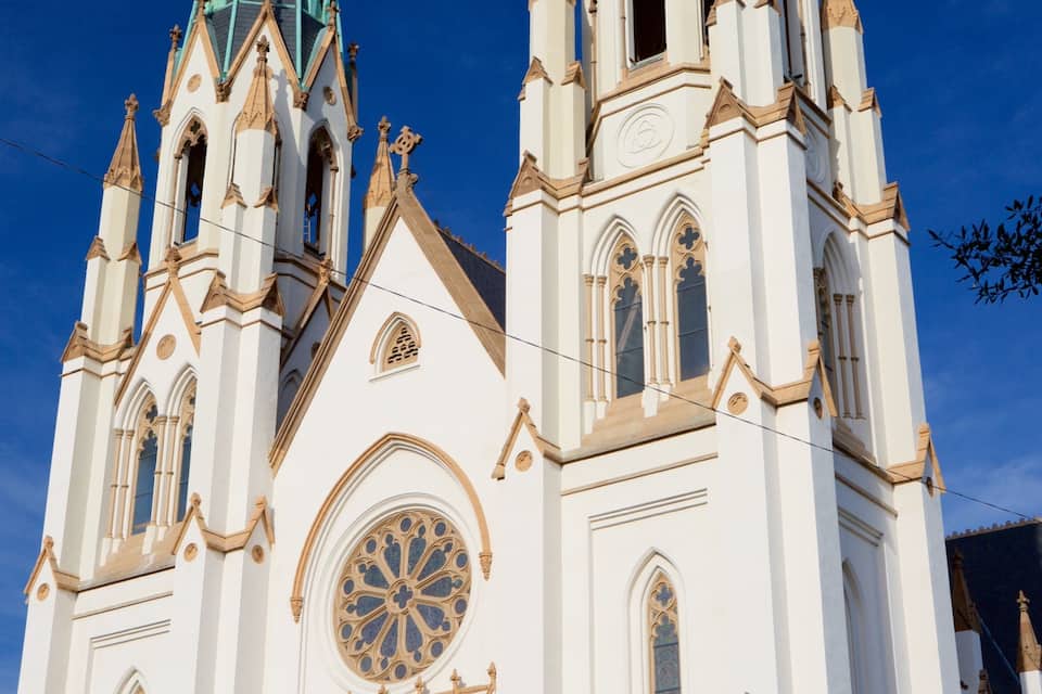 A white church with a large circular window and two tall spires.
