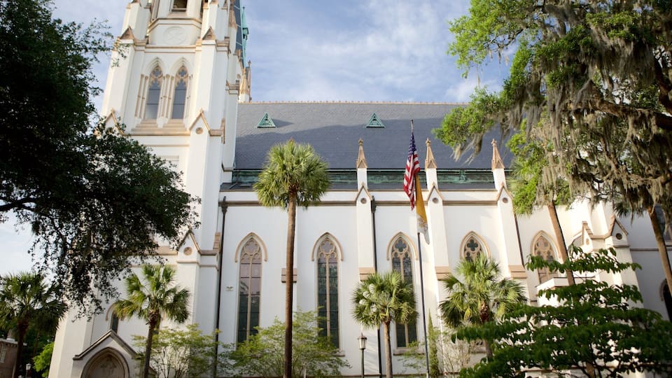 A church with a steeple, palm trees, and flags.