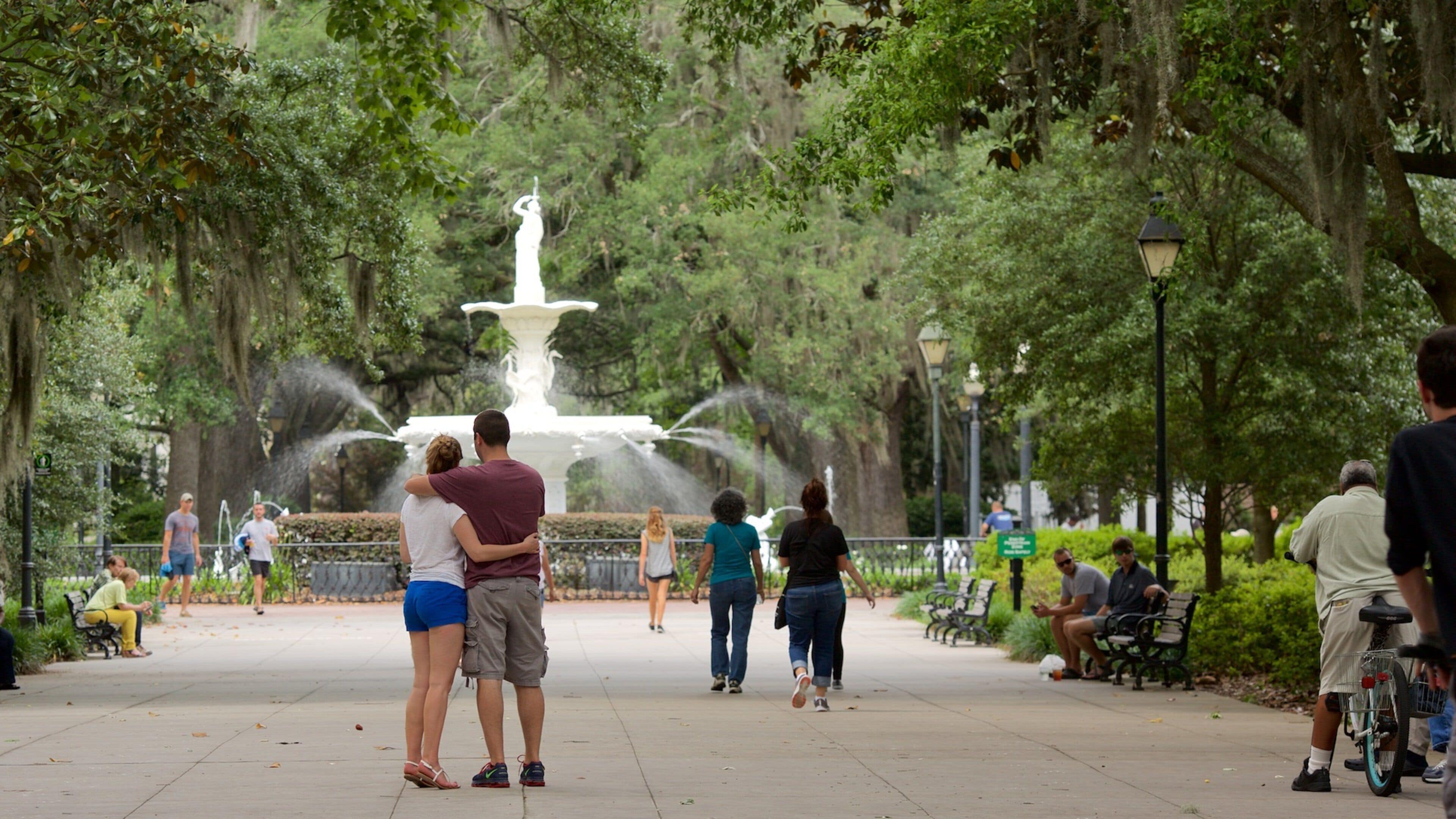 Forsyth Park que inclui um jardim e uma fonte assim como um pequeno grupo de pessoas