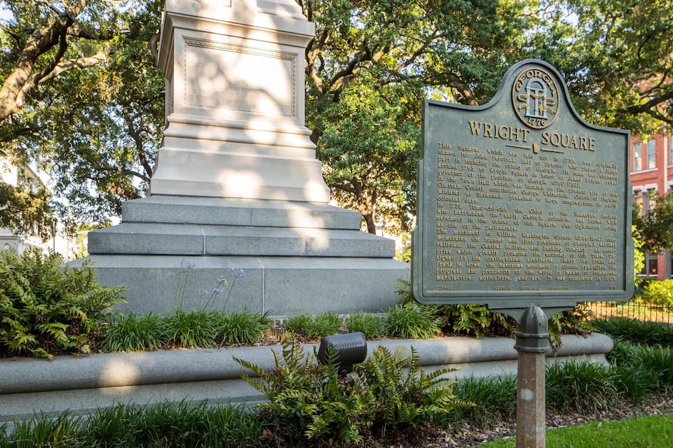 Marcador histórico de la Plaza Wright con un monumento al fondo.