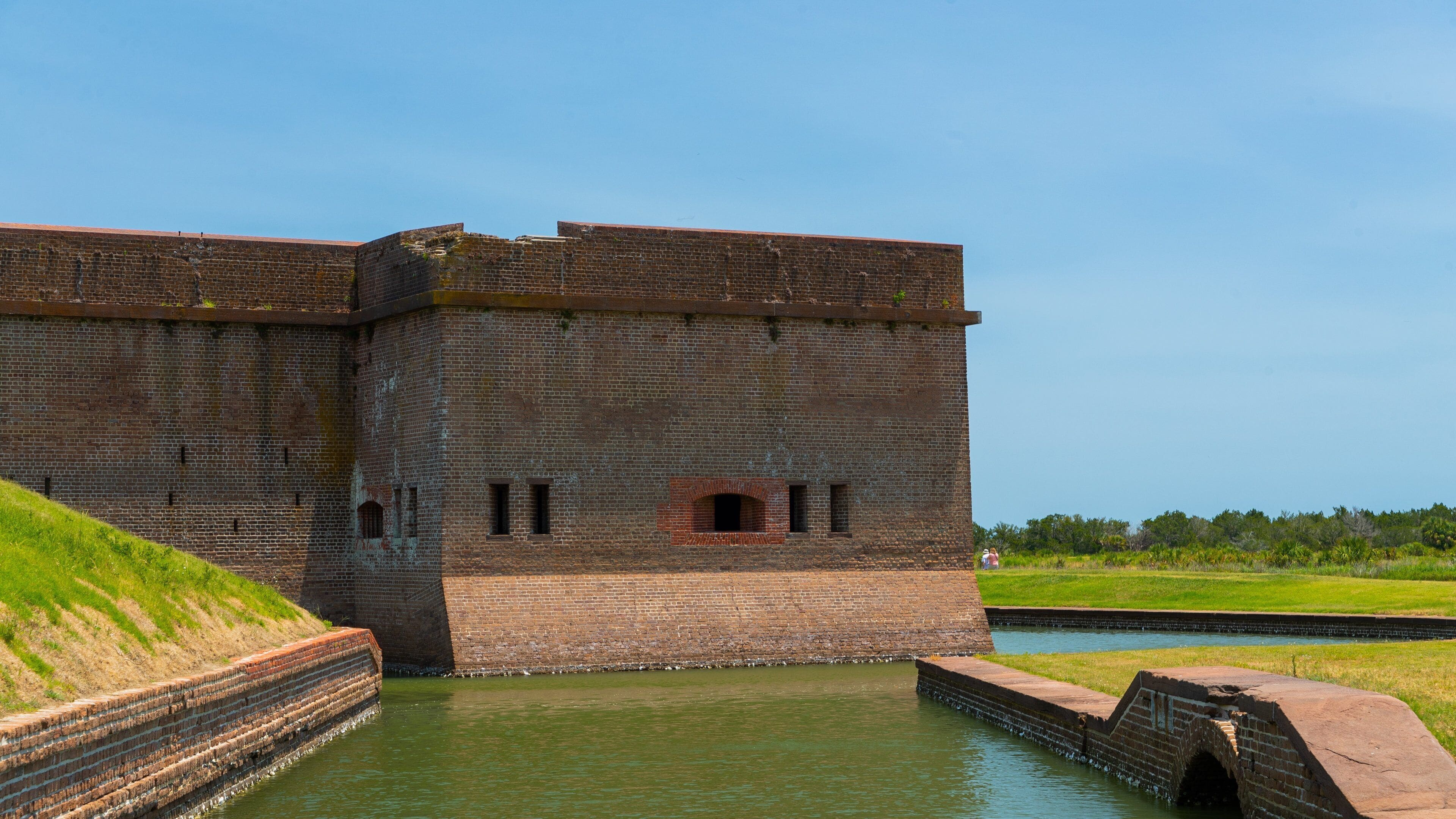 A large brick fort with a moat and a small bridge.