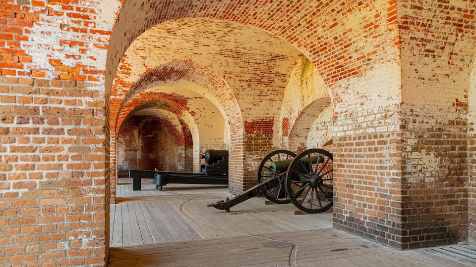 An interior with brick arches and cannons.