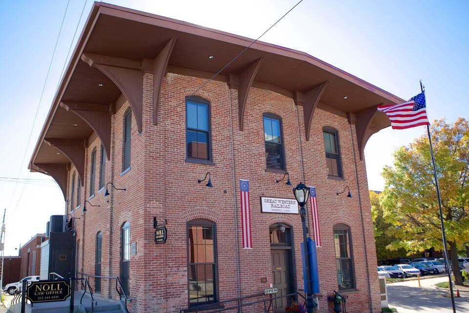 A brick building with a sign reading "Great Western Railroad Springfield, Illinois" and an American flag.