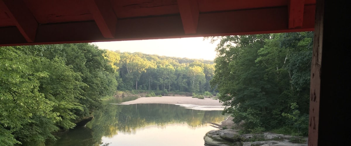 A view of a view from a coveraged bridge. This is just one of the many in the area, build in 1880's and still in good condition (just one of the reasons to cover the bridges is that they will last longer, don't believe aesthetics played a role in the design).
One way to explore Turkey Run State Park is by tube, kayak or canoe on the Sugar Creek.  Snakes (friendly ones only), limestone rock formations and an old car (an Edsel?) stuck in the banks of the river can be admired from the water. This park is a true Hoosier trove. 
http://www.in.gov/dnr/parklake/2964.htm
If you are into covered bridges: http://www.coveredbridges.com/