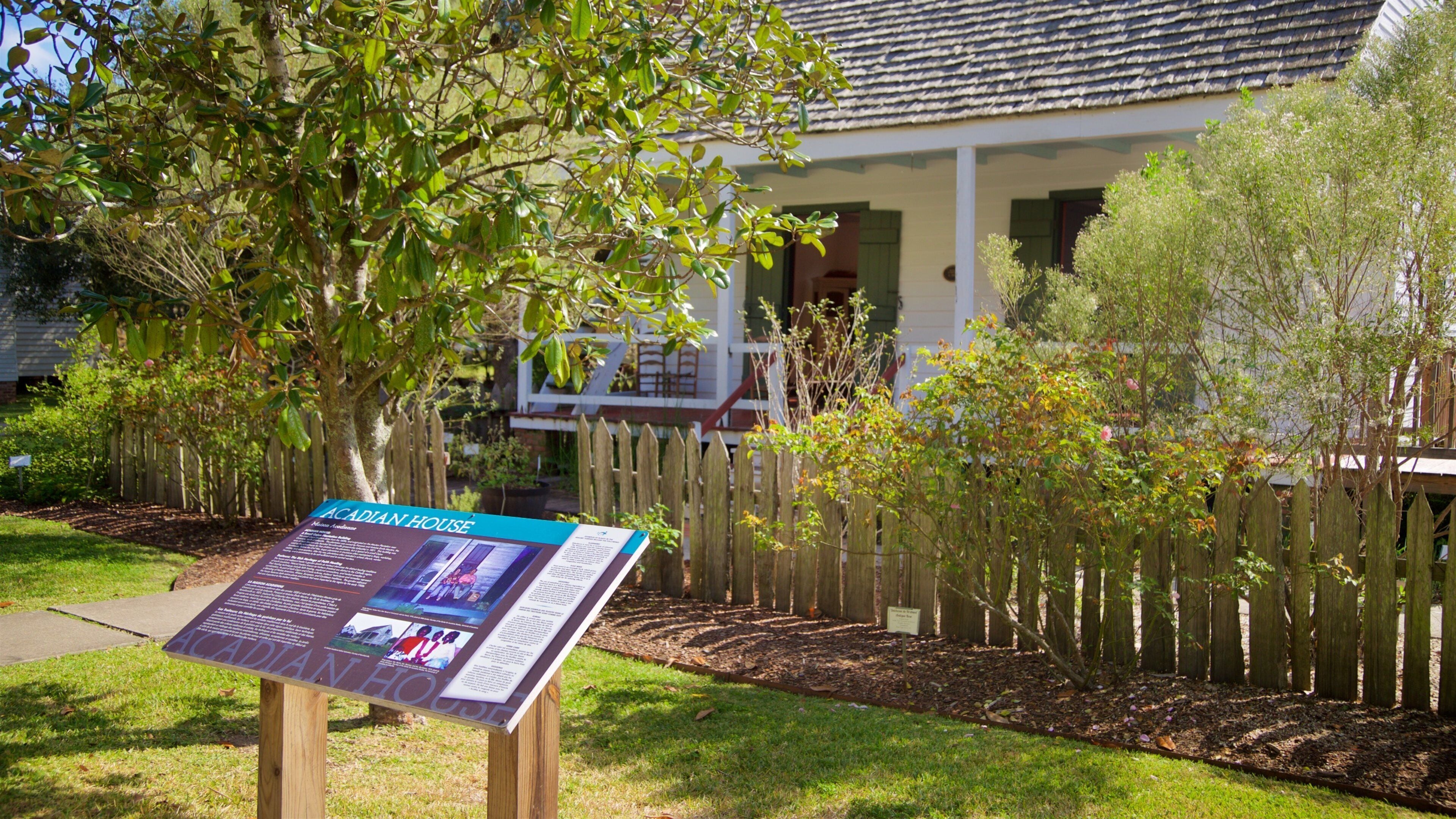 Vermilionville which includes a house, signage and a park