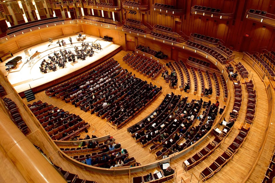 Un gran auditorio circular con asientos en niveles y un escenario al frente.
