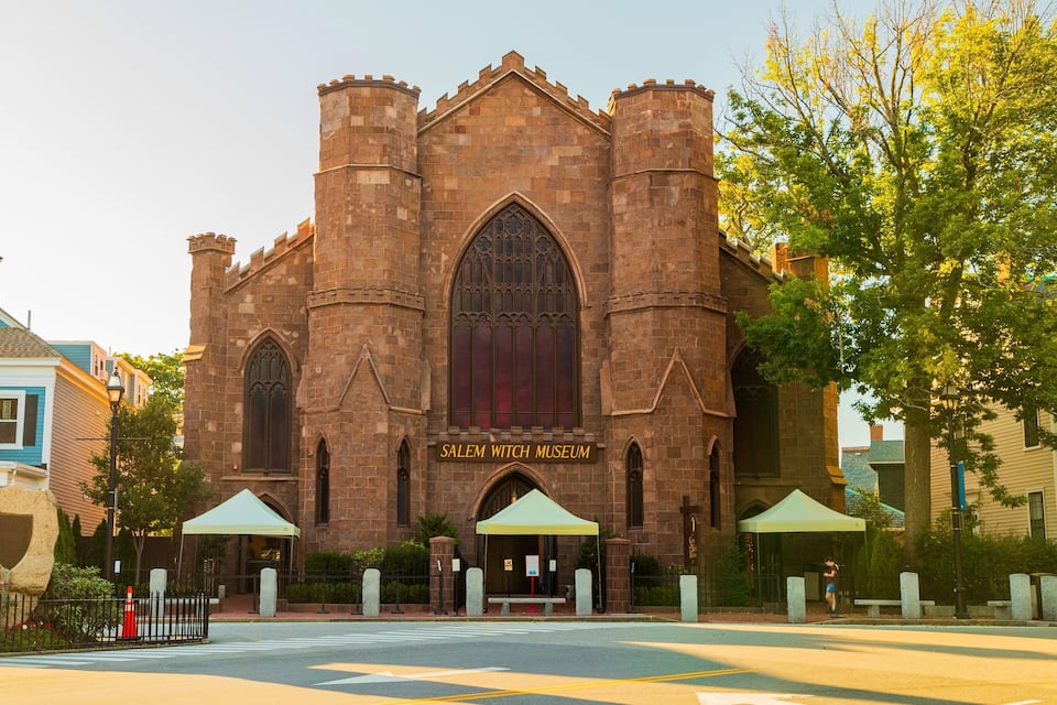 A historic building with a large arched window and a sign reading "Salem Witch Museum".