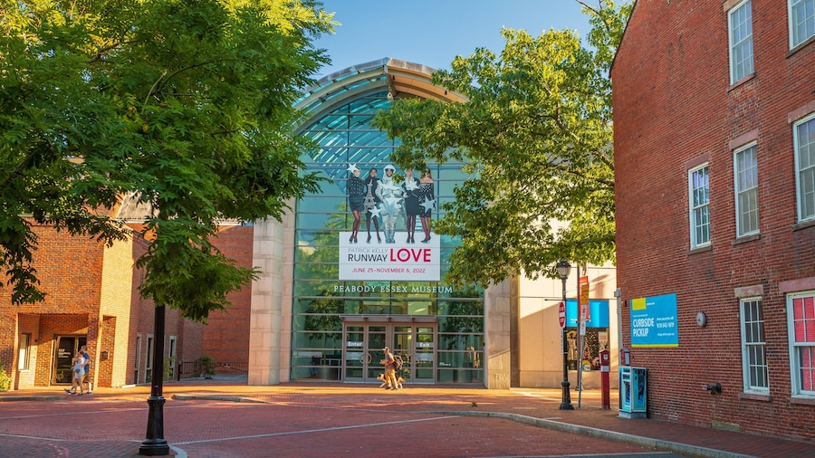 Un edificio de ladrillo con fachada de vidrio y un cartel anunciando el evento Patrick Kelly Runway of Love en el Museo Beabody Essex.