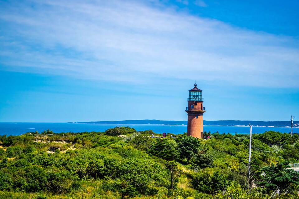 Un phare entouré d’une végétation luxuriante et donnant sur l’océan.