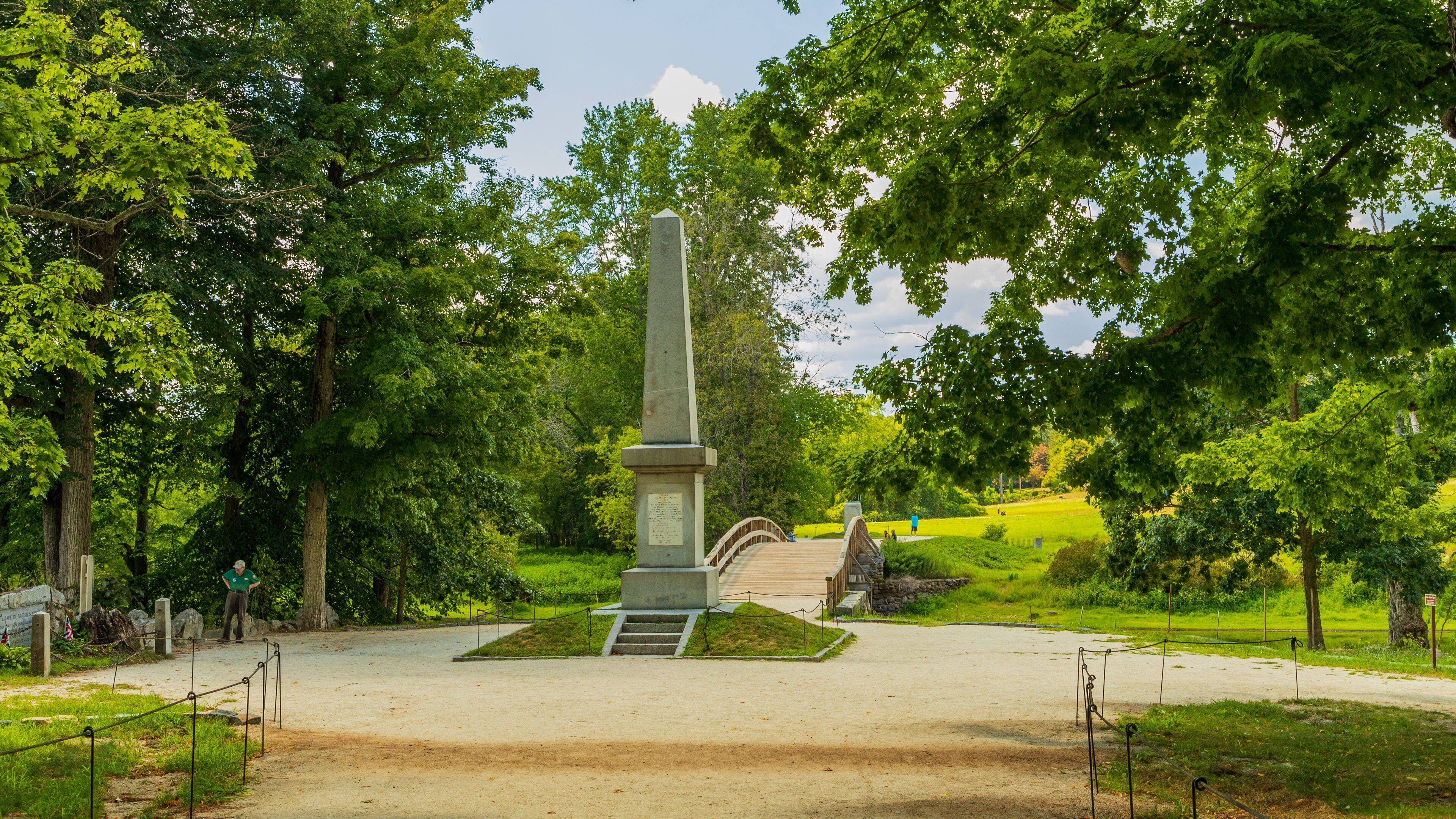 A monument surrounded by lush greenery and a paved walkway.
