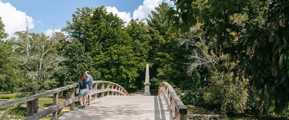 Old North Bridge showing a bridge and a pond as well as a couple
