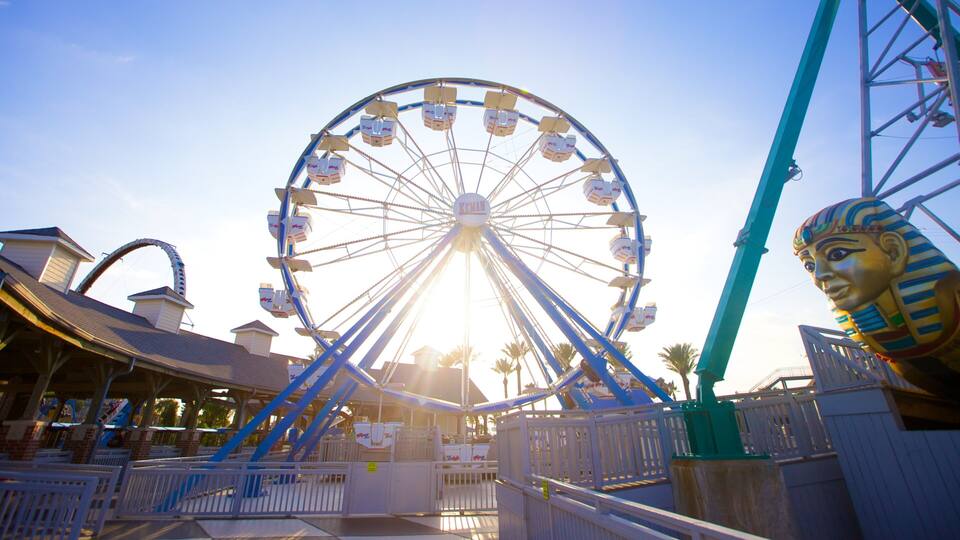 A Ferris wheel at an amusement park with a large Egyptian statue.