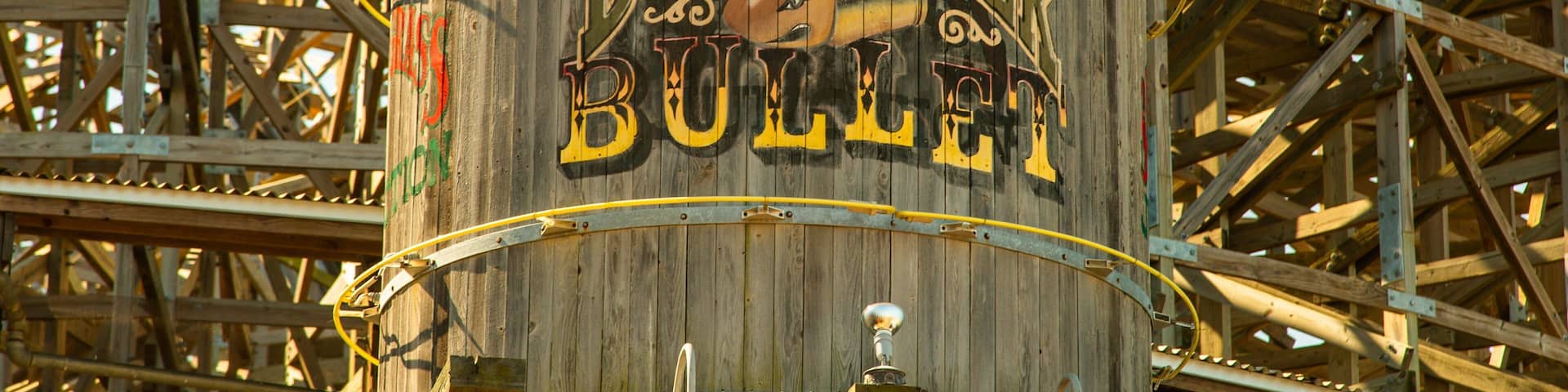 A wooden barrel with the words "Boardwalk Bull" painted on it, surrounded by a metal framework.