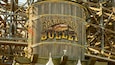 A wooden barrel with the words "Boardwalk Bull" painted on it, surrounded by a metal framework.