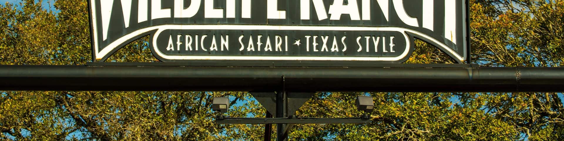 A sign for Wildlife Ranch with silhouettes of animals and the text "African Safari Texas Style".