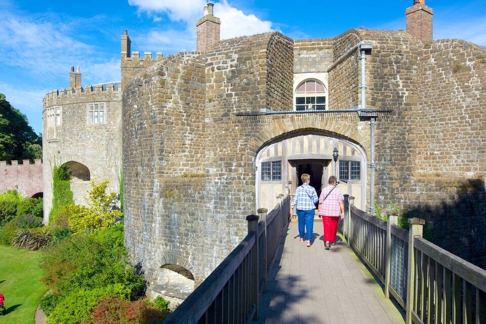 A historic stone castle with a wooden bridge leading to its entrance.