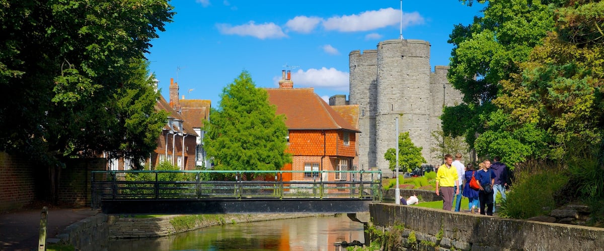 Jardines de Westgate y torres mostrando patrimonio de arquitectura, un río o arroyo y una pequeña ciudad o pueblo