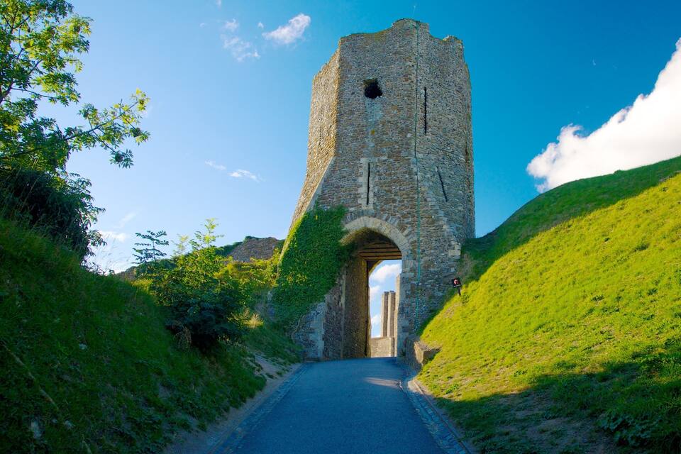 Een stenen toren met een gebogen toegang op een heuvel.