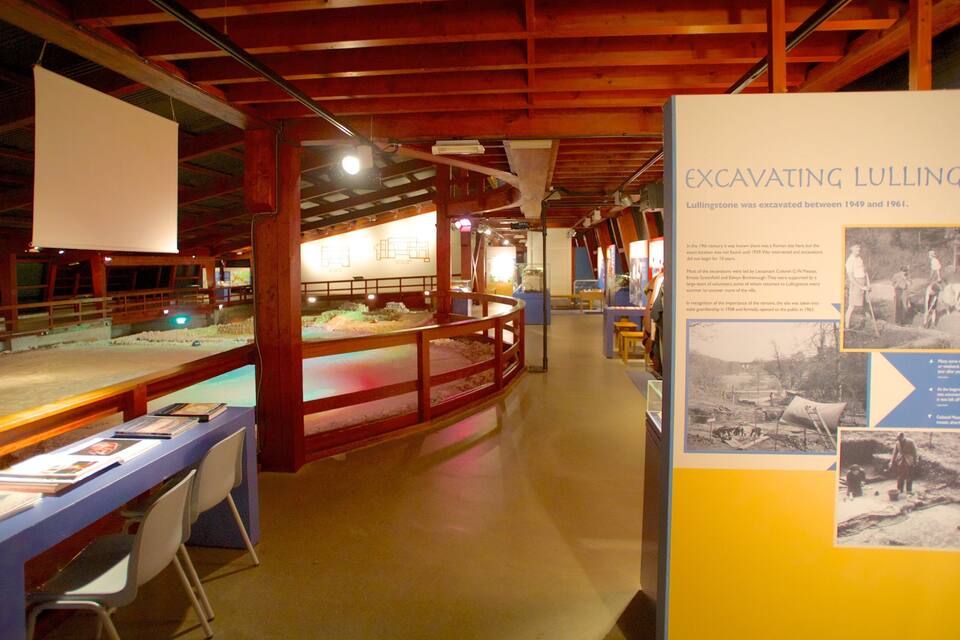 An indoor exhibit with displays of artifacts and informational panels about excavating Lullingstone.