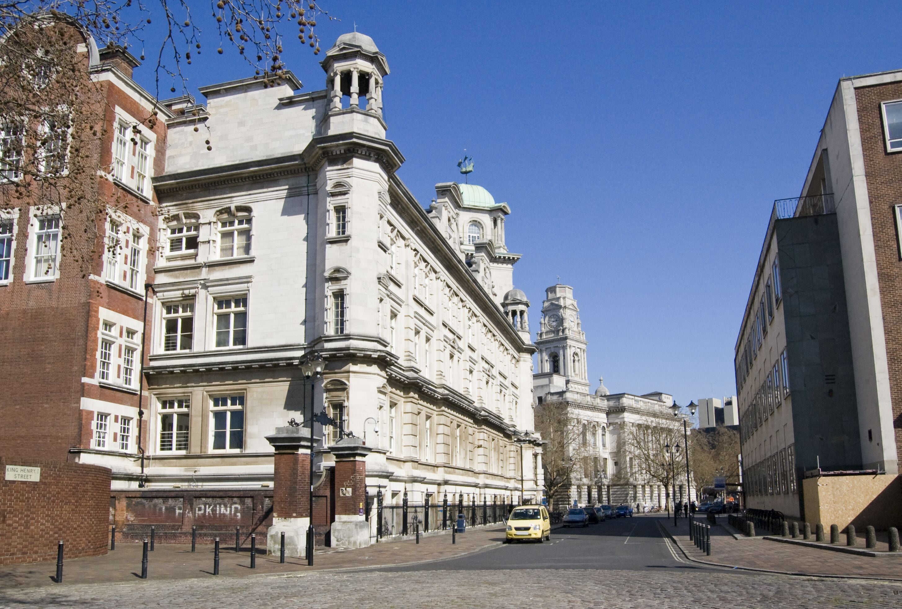 View of King Henry I Street in central Portsmouth, Hampshire.  The University's Park Building is on the left hand side with the Guildhall in the distance.; Shutterstock ID 112343015