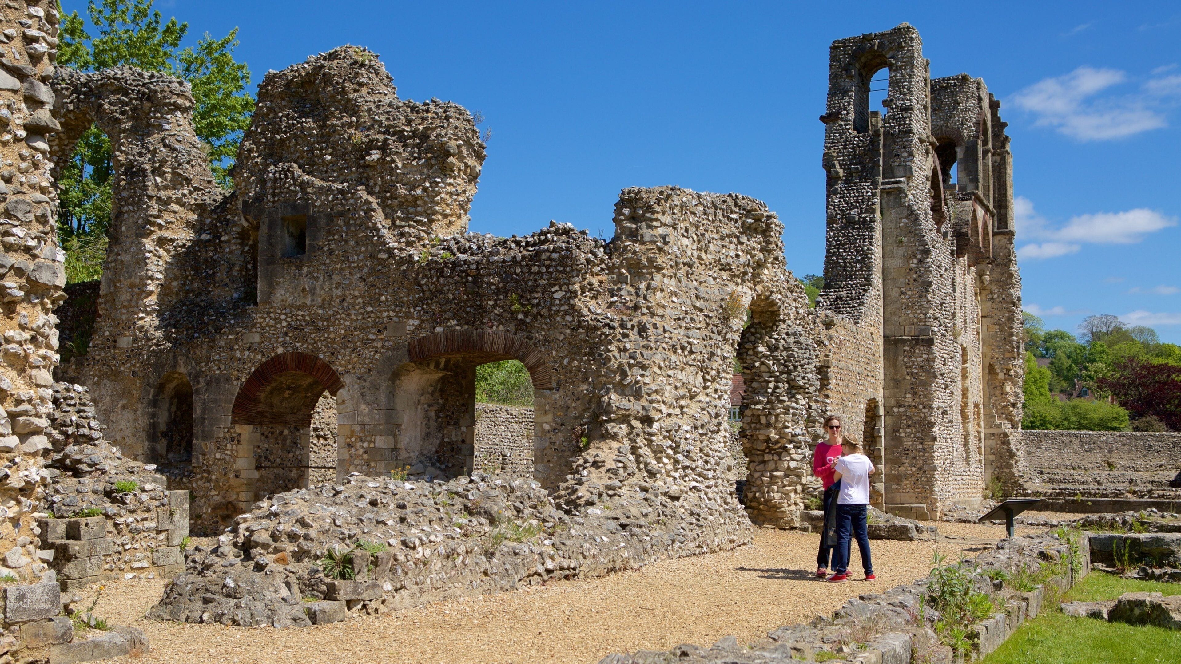 Ancient stone ruins with arches and a tall tower.