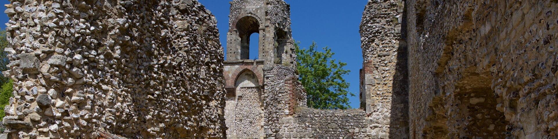 An ancient stone structure with arched doorways and a tower.