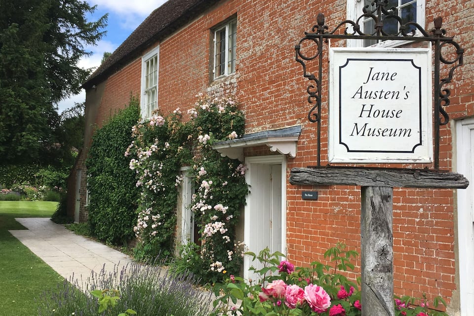 Jane Austen's House Museum with a brick facade, white door, and a signboard.