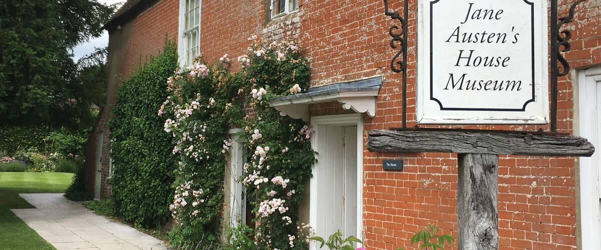 Jane Austen's House Museum with a brick facade, white door, and a signboard.