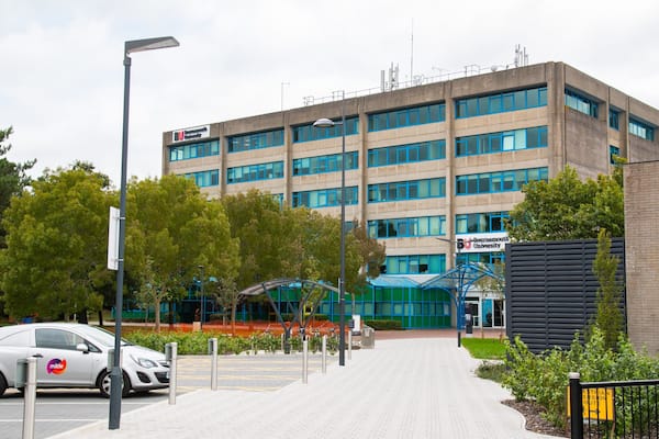 Um edifício moderno com uma placa da Universidade de Bournemouth.