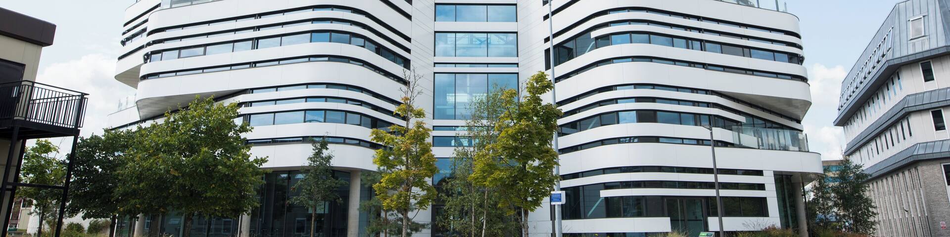 A modern building with curved architecture and multiple windows.