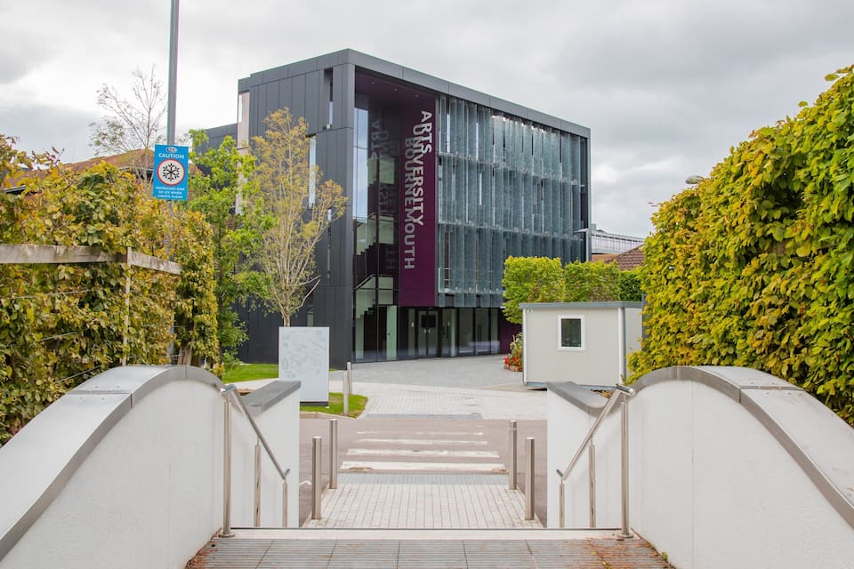 Um edifício moderno com uma placa que diz "Arts University".