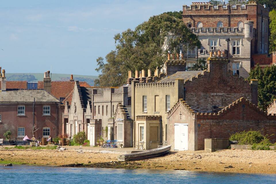 A riverside town with historic buildings, including a castle-like structure.
