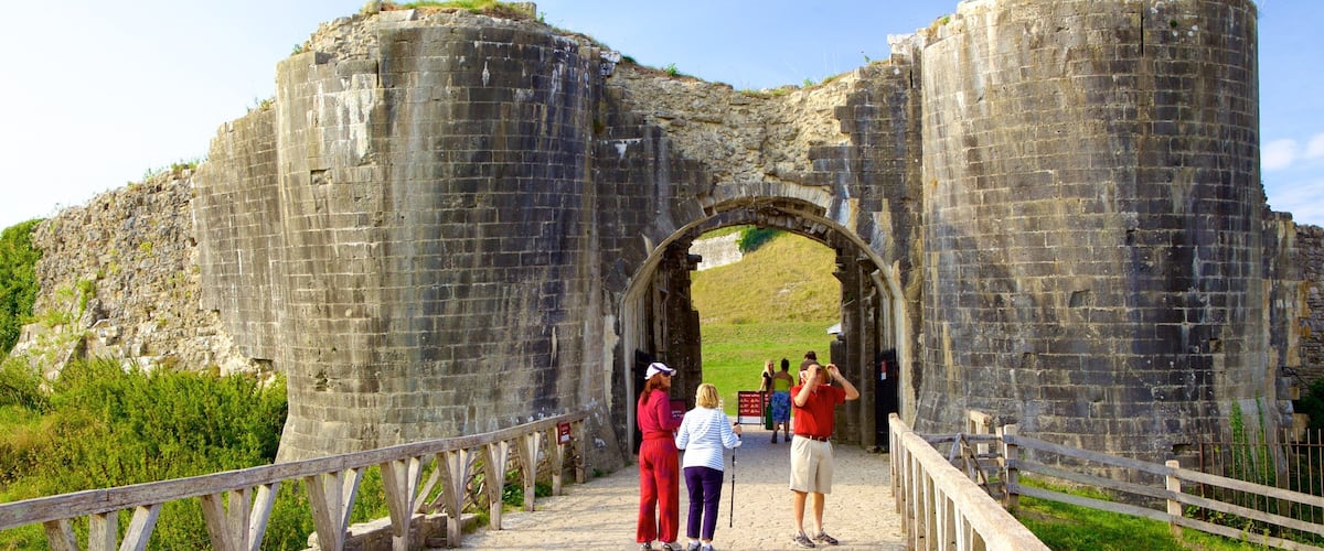 Corfe Castle que incluye ruinas de edificios y elementos patrimoniales y también un grupo pequeño de personas