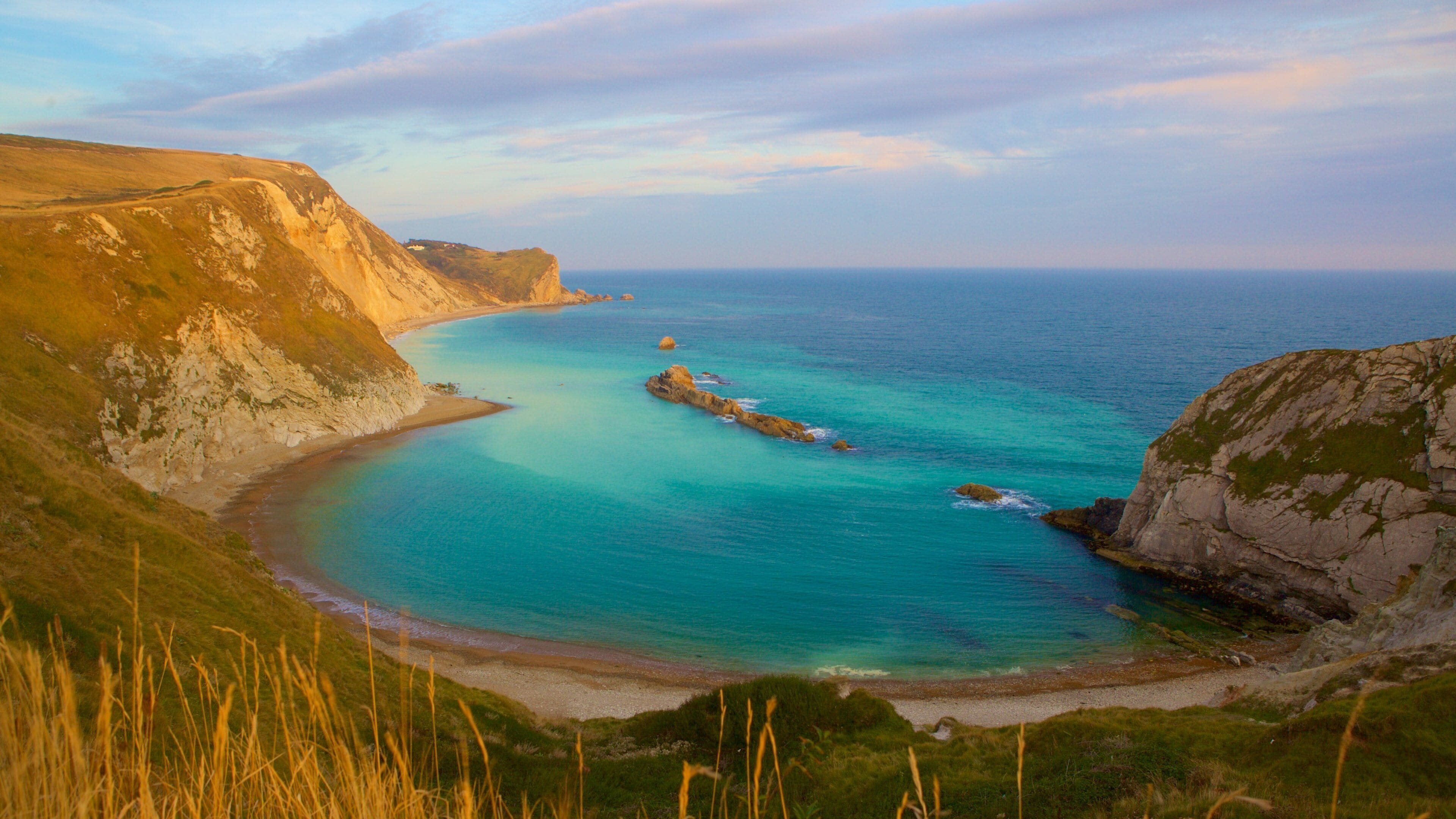 Durdle Door which includes a bay or harbor and rocky coastline