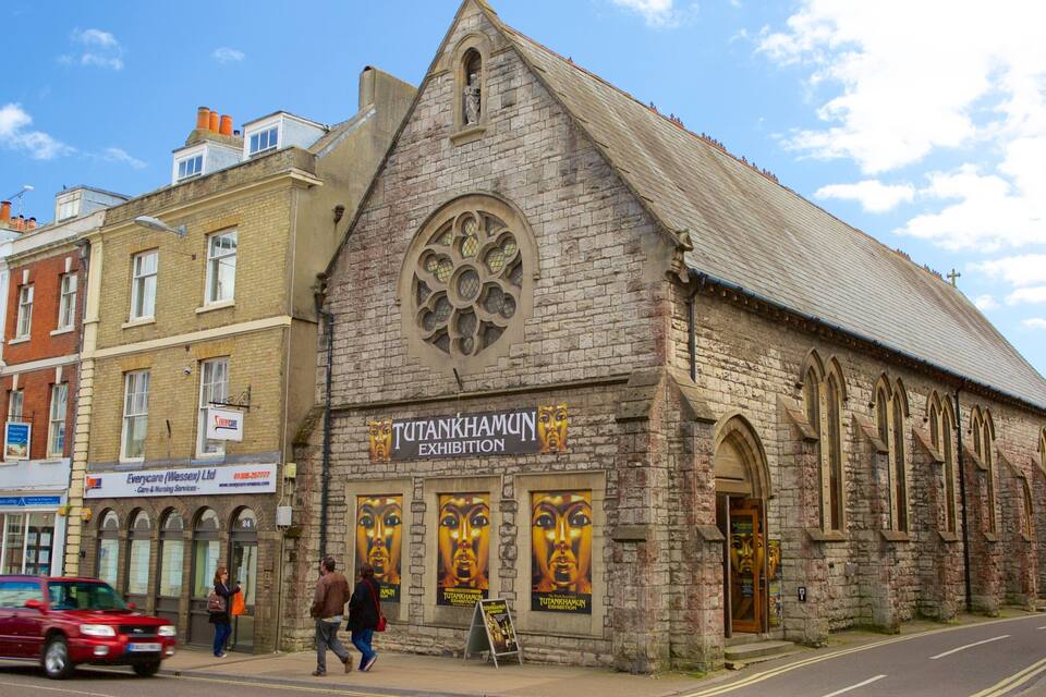 A historic building with a large stained glass window and a sign for the Tutankhamun exhibition.