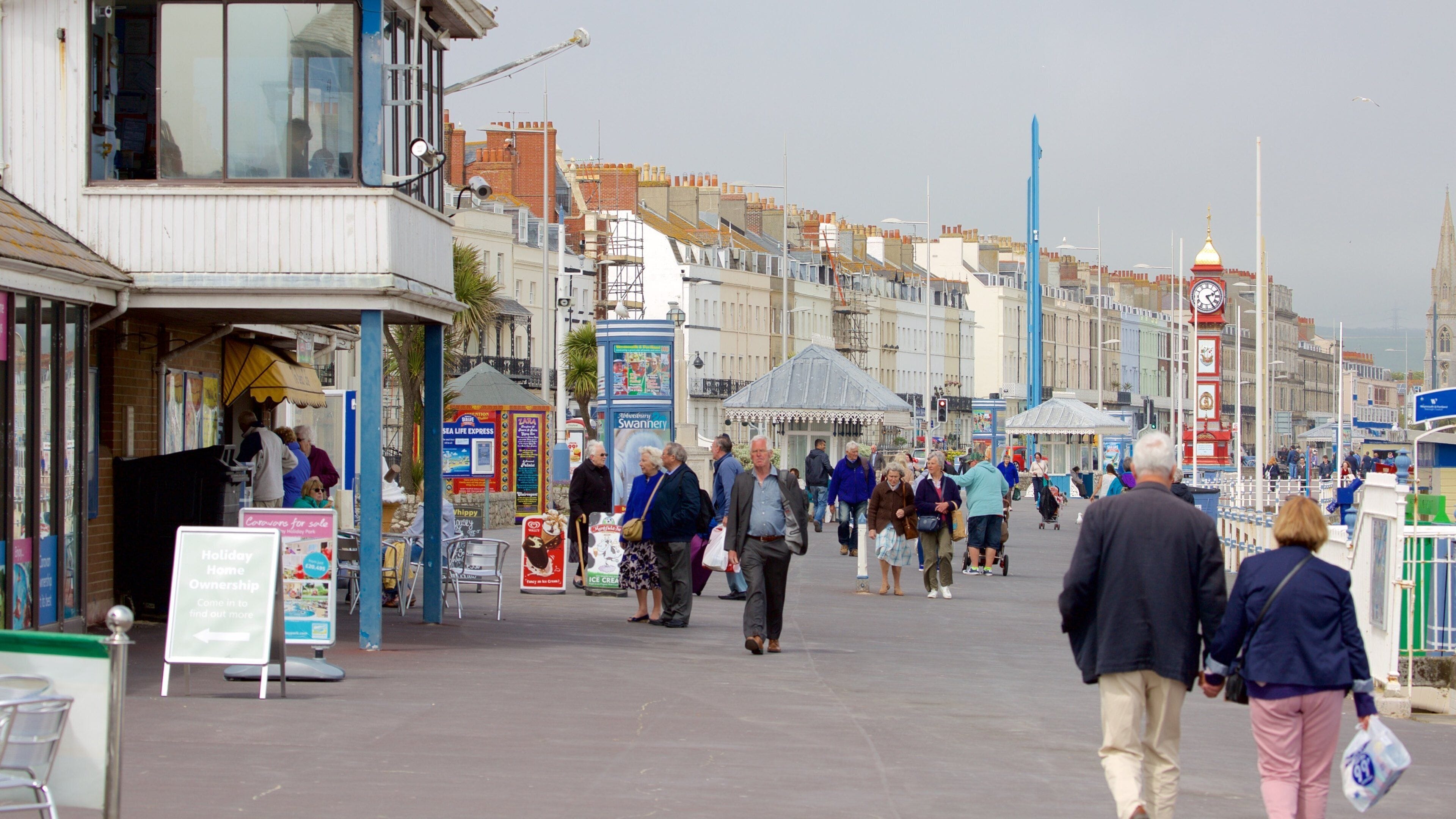 Weymouth Beach som visar gatuliv såväl som en stor grupp av människor