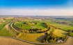 An aerial view of a historic castle surrounded by green fields and a small town.