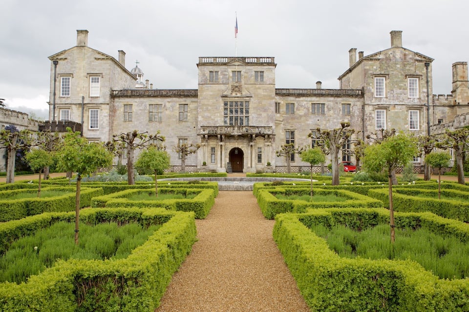 Un bâtiment historique doté d’un jardin symétrique et d’un chemin central.