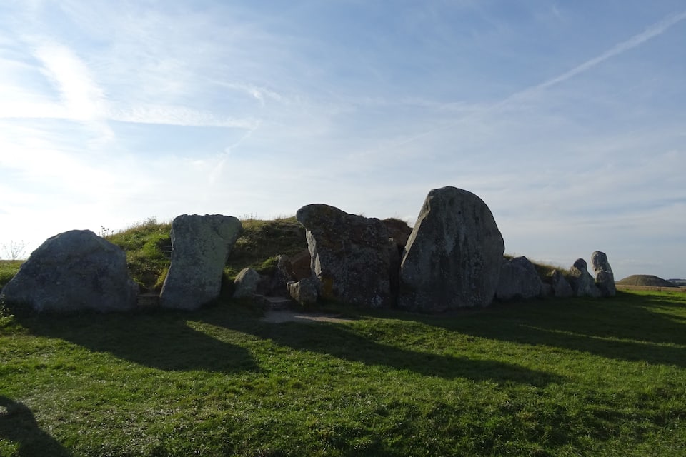 A stone circle with large upright stones in a grassy field.