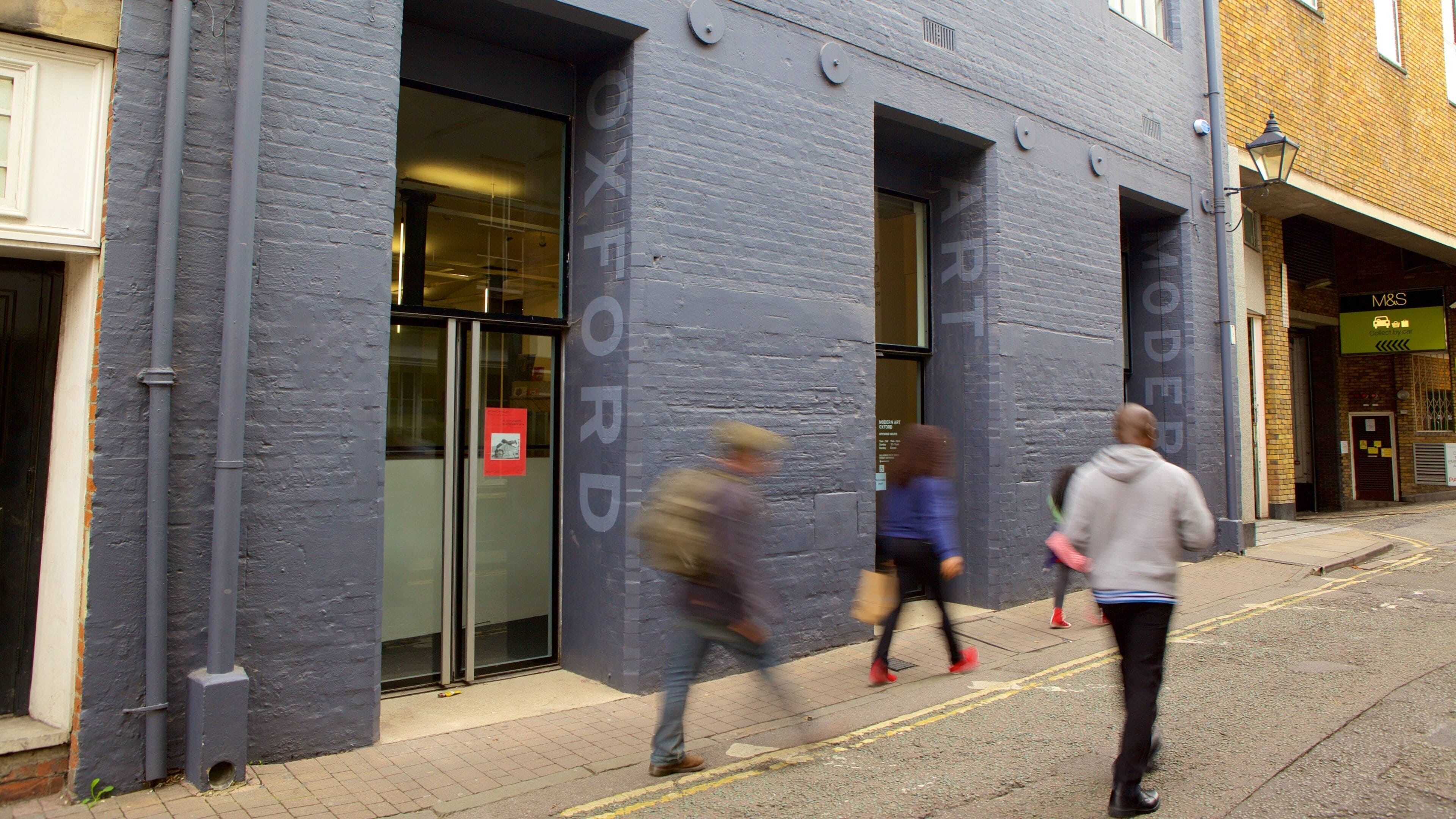 Modern Art Oxford som inkluderar skyltar såväl som en liten grupp av människor