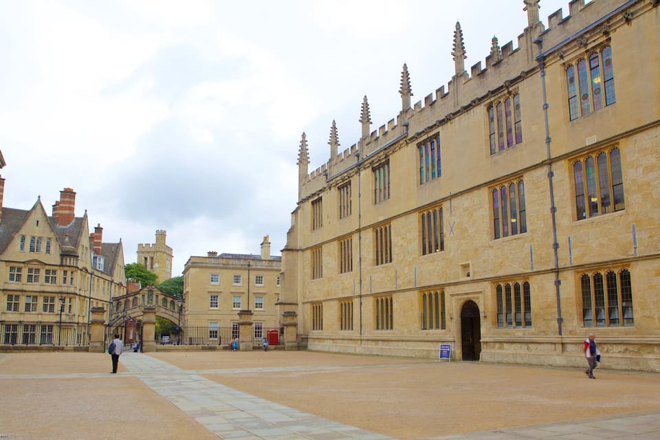 A historic courtyard with Gothic architecture, including pointed arches and a large arched entrance.